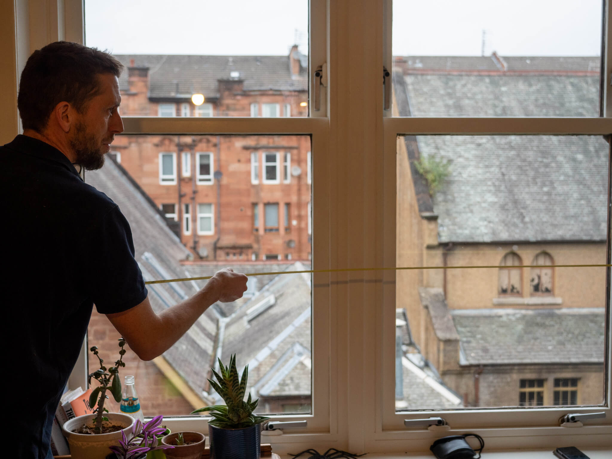 Chris measuring window in Glasgow, retrofit consultant at work