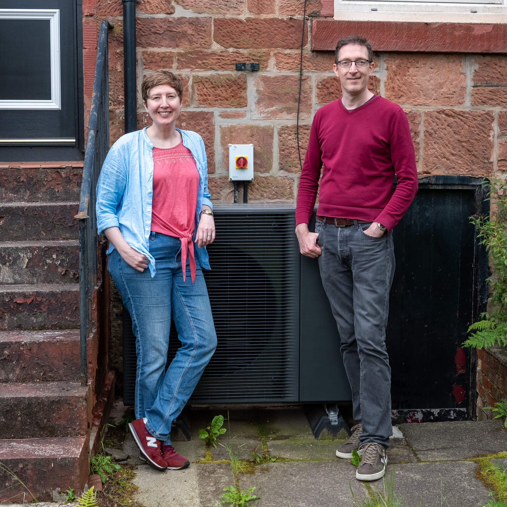 kat and iain loco home members beside a heat pump in their shawlands brownstone property. They got a heat pump and got their funding advice and guidance from loco home retrofit
