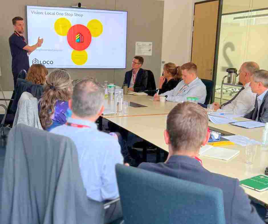 Ofgem Board visits Glasgow for Loco Home presentation sitting in board room as founder talks about his retrofit one stop shop