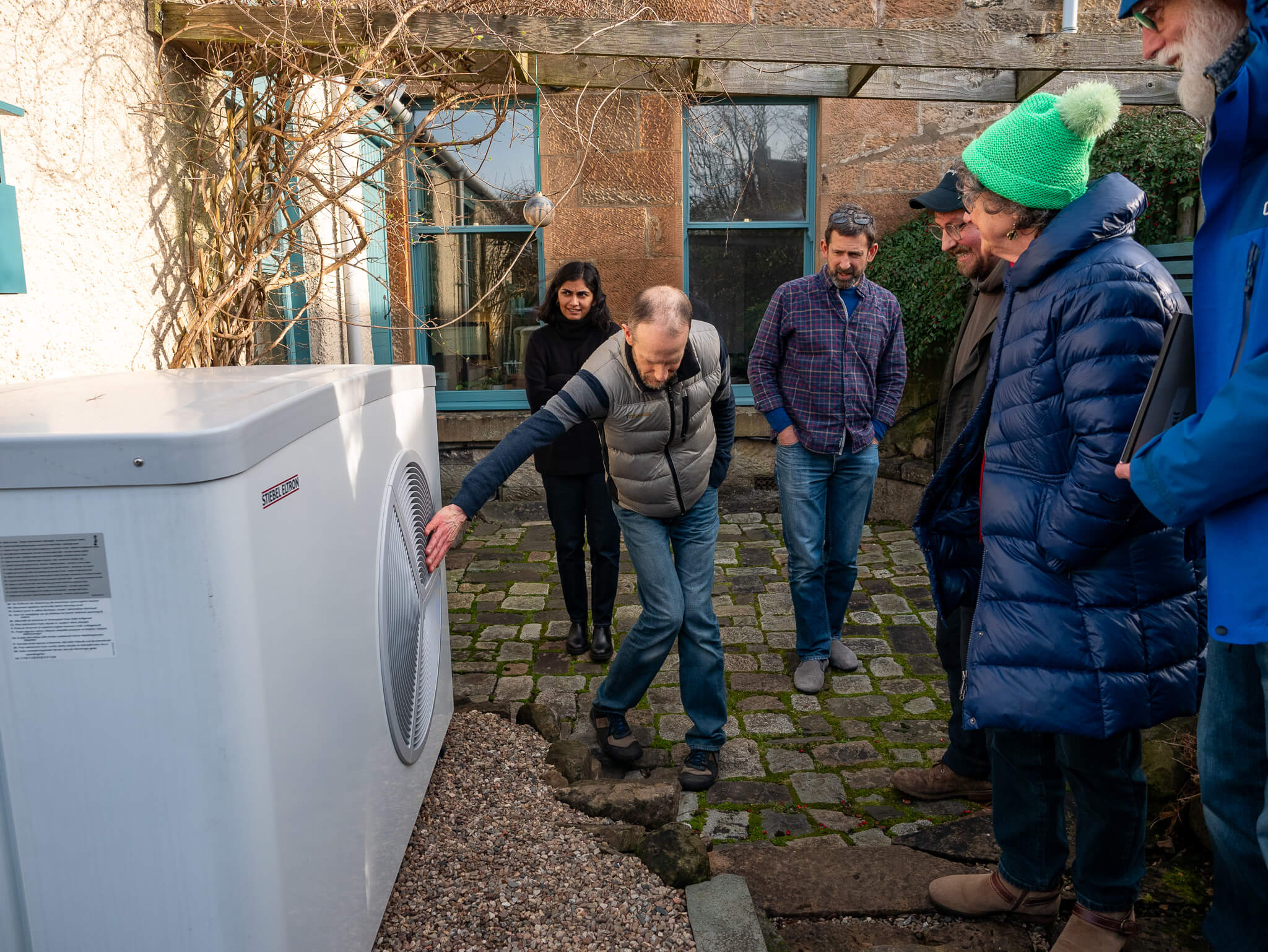 Group outside in Glasgow southside learning about eco grant insulation Glasgow and feeling supported as home owners to tackle climate change

